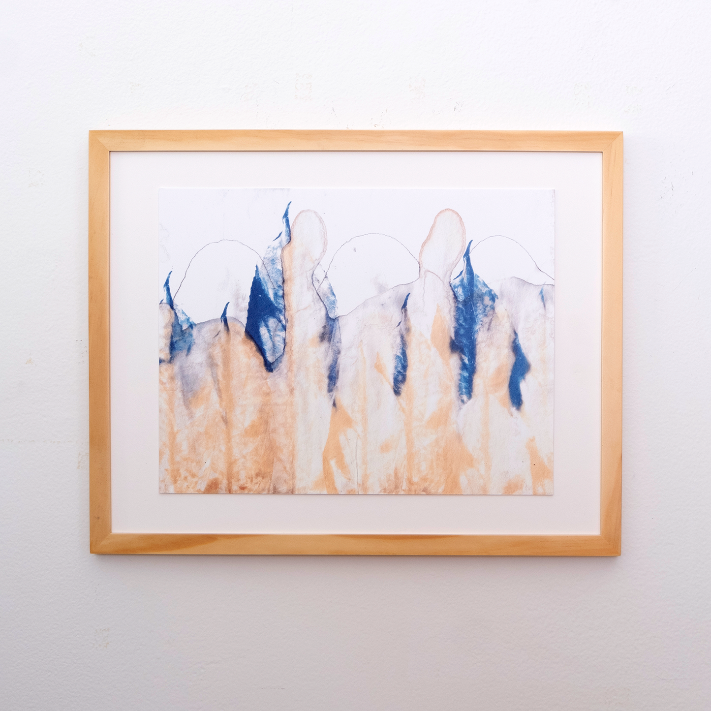tea chromatogram with blue leaves filling the page like a mountain range. A tan chromatogram spreads from the bottom of the page. This rectangular print has a light wooden frame around it.